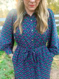 Woman wearing a patterned dress with a blurred outdoor background